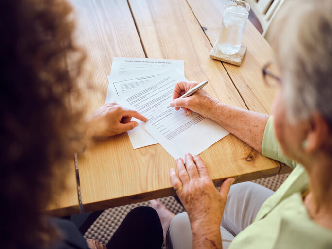 Elderly woman signing SSD documents